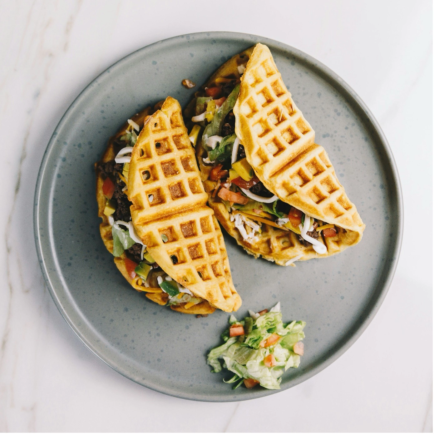 Waffeltacos mit Gemüsefüllung auf grauem Teller