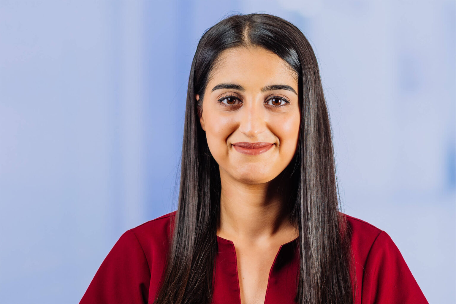 Frau in rotem Oberteil lächelt freundlich