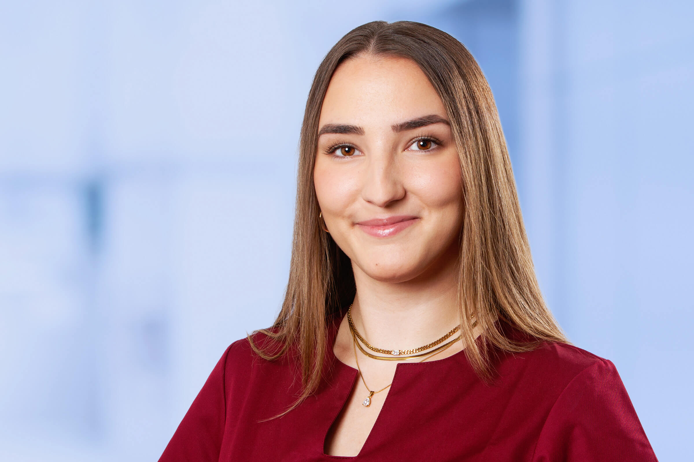 Junge Frau in rotem Oberteil lächelt freundlich.