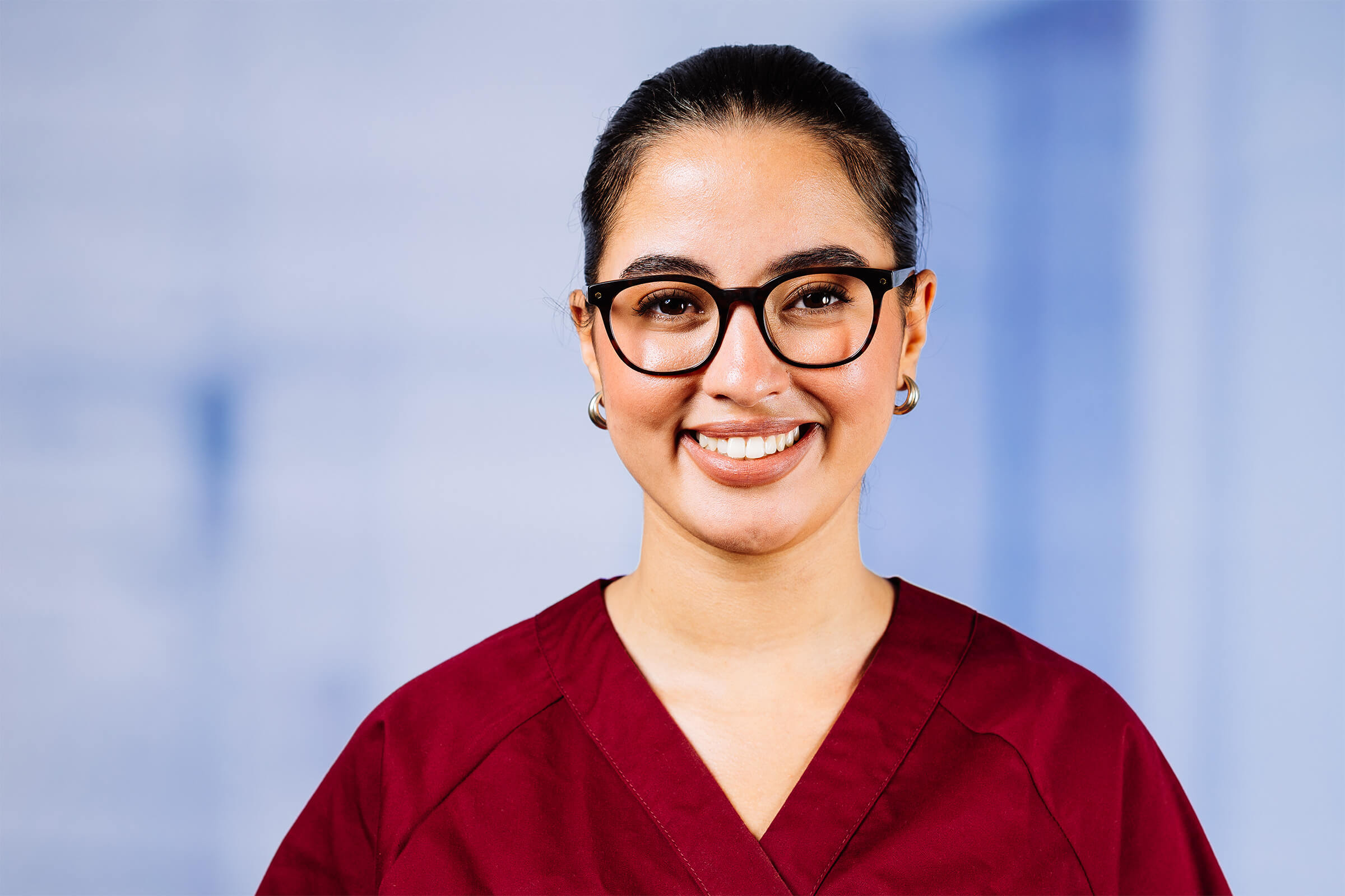 Lächelnde Frau in roter Krankenhauskleidung