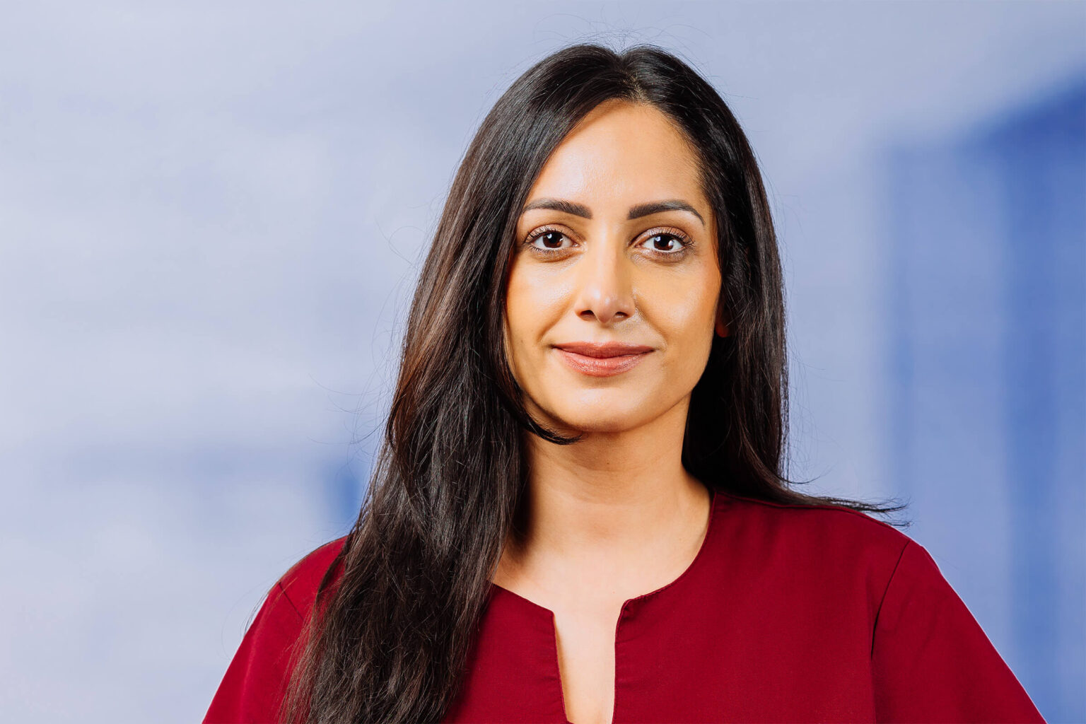 Porträt einer Frau in rotem Oberteil, freundlich lächelnd