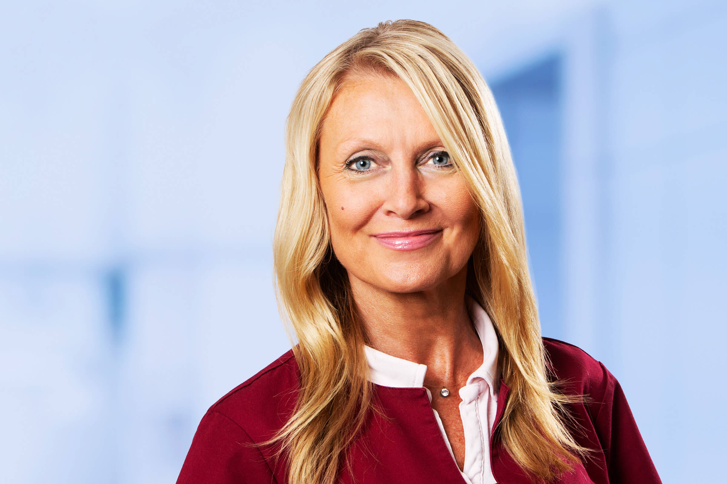 Lächelnde blonde Geschäftsfrau in rotem Blazer