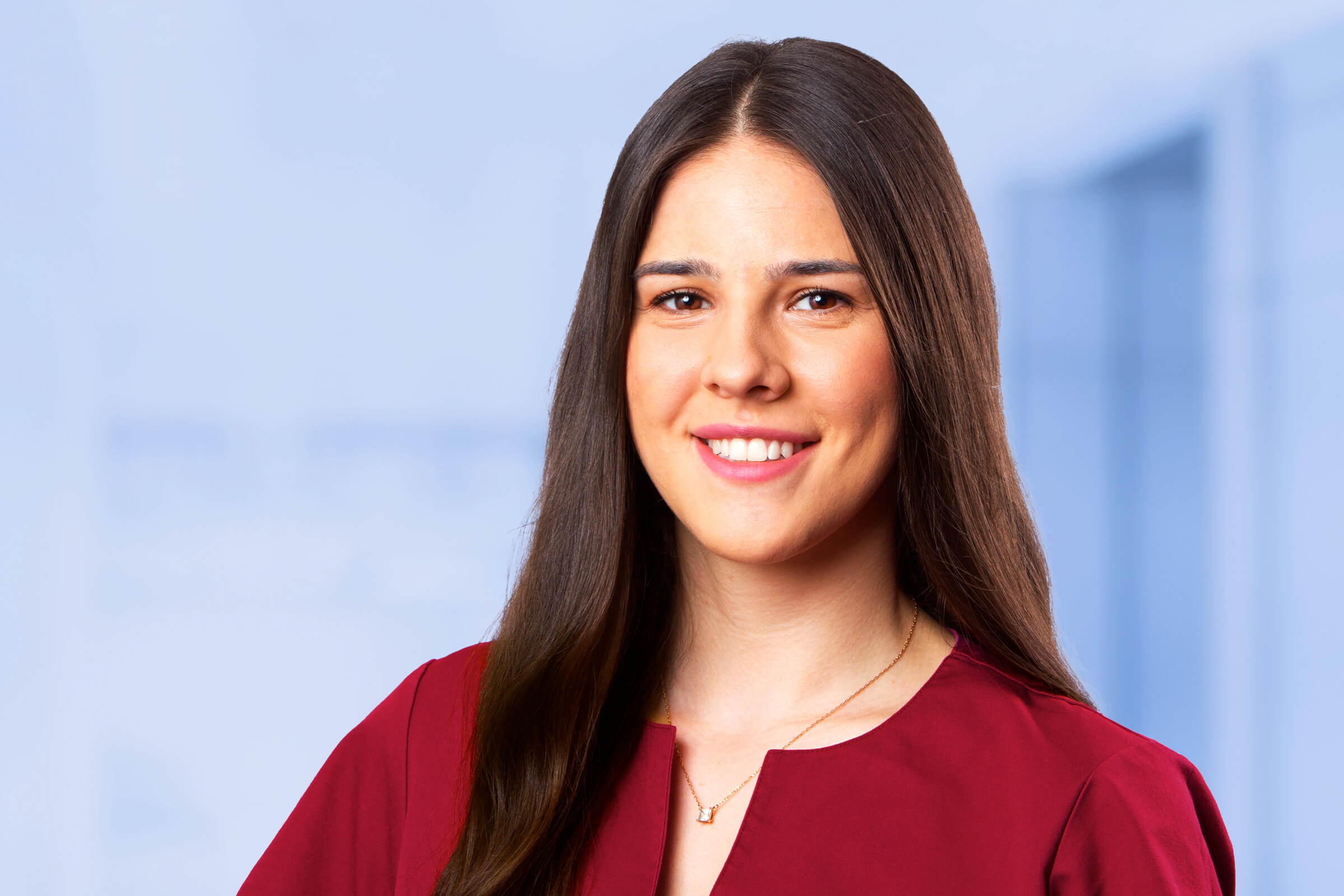 Frau in rotem Oberteil lächelnd im Büro