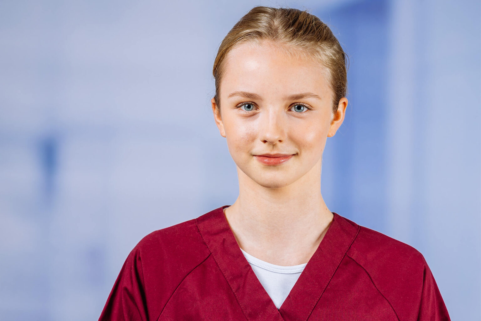 Junge Frau in rotem Arbeitsmantel lächelt