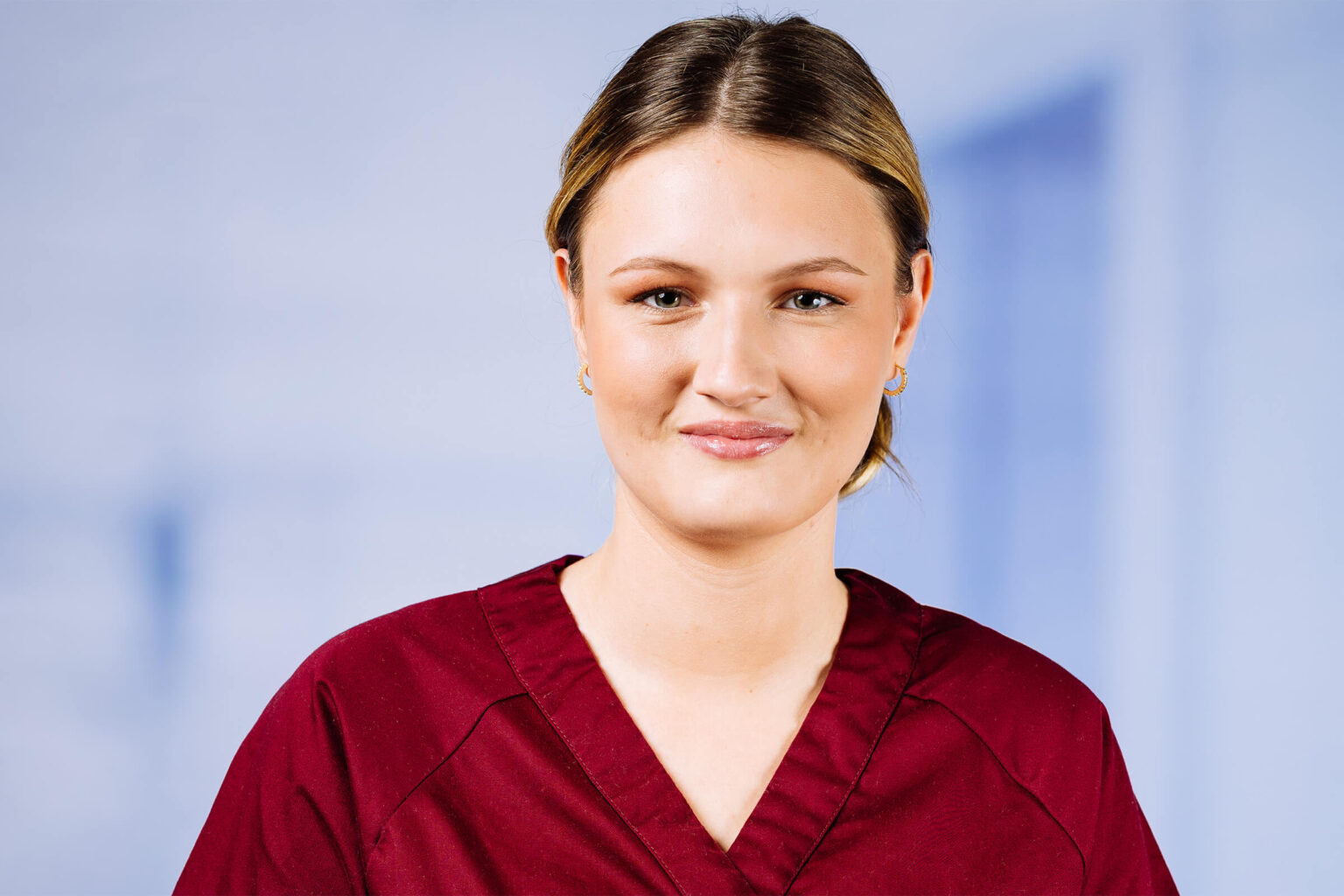 Junge Frau in rotem Oberteil lächelt freundlich